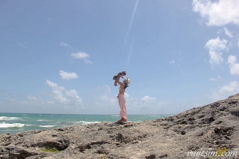 riviera-maia-com-bebe-praia-tulum Mãe e bebê em pedra à beira-mar em praia de Tulum, no México
